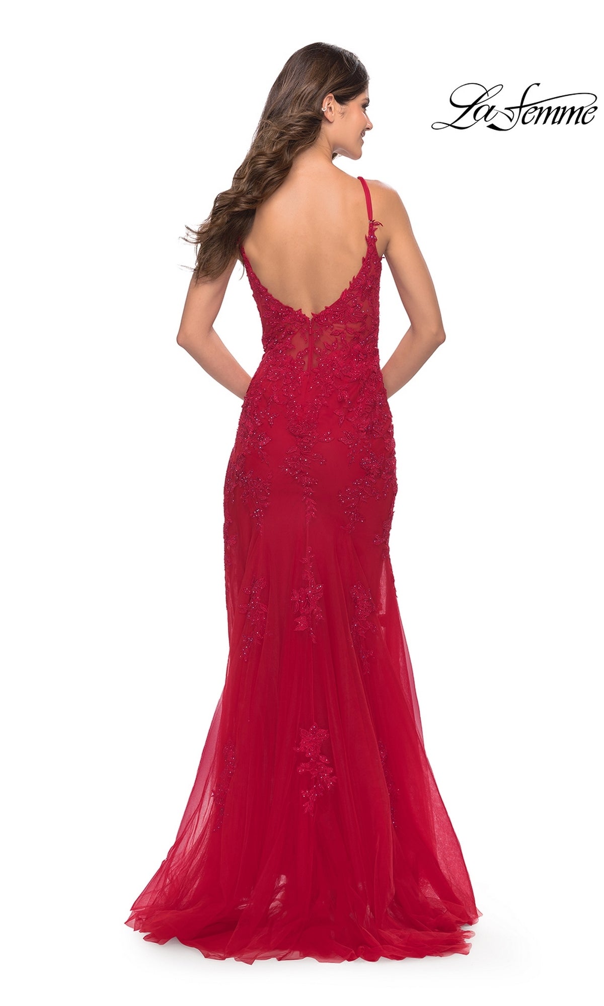 A woman faces away in the La Femme Sheer-Corset-Bodice Long Prom Dress 30767, a fitted, floor-length red gown with lace embroidery, thin straps, a low back, and delicate floral details. The La Femme logo appears in the corner.
